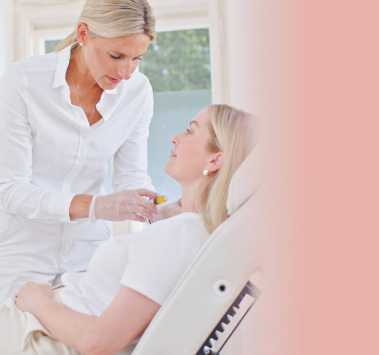 Priv. Doz. Dr. Katja Emmanuel in ihrer Praxis, die einer Frau im Behandlungsstuhl eine Spritze im Halsbereich setzt.