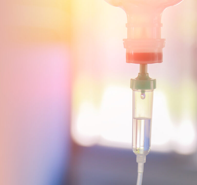 Der Tropf einer Infusion in pastelligen Farbtönen