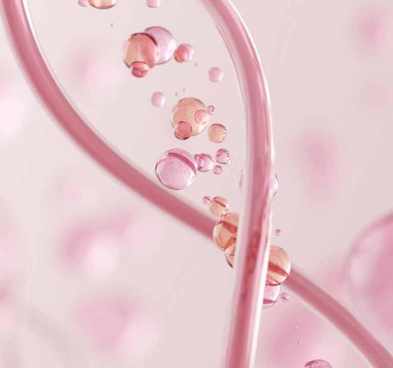 Übereinander gelegte Infusionsschläuche mit rosa Flüssigkeit und rosa-orange-farbene Kugeln mit Flüssigkeit.