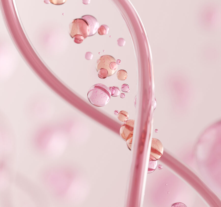 Übereinander gelegte Infusionsschläuche mit rosa Flüssigkeit und rosa-orange-farbene Kugeln mit Flüssigkeit.