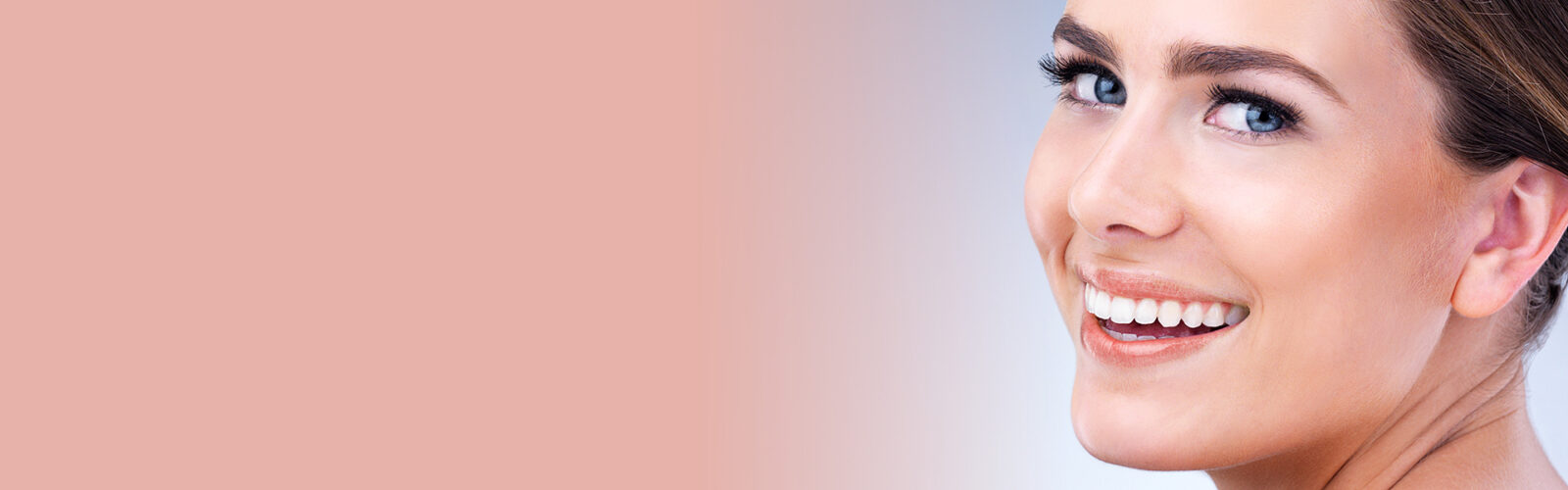 Eine lächelnde, junge Frau mit rosa Lippenstift auf rosa-hellblauem Hinergrund - 