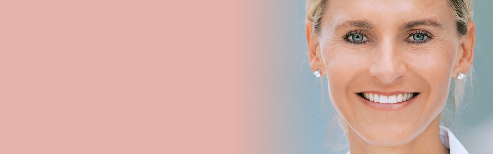 Priv. Doz. Dr. Katja Emmanuel, lächelnd auf rosa-hellblauem Hinergrund - 